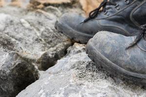 bota de cuero trekking en la roca foto