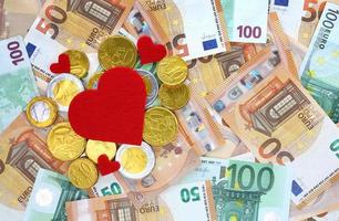 Red felt hearts and gold chocolate euro cents on 50 and 100 euro banknotes background. Valentines Day, love and money concept. Sopping, prices, sales, discounts, holiday gifts, congratulations. photo