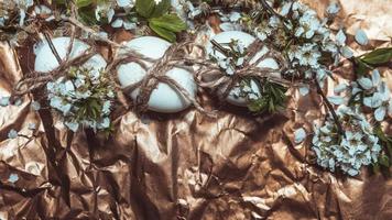 White Easter eggs with flowers on golden background, close up photo