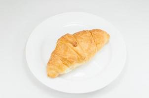 Croissant on white dish on white background photo