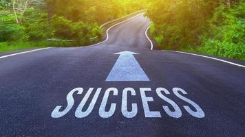 Success text written on road concept for business planning strategies and challenges or career path opportunities and change, road to success concept, Success word on street photo