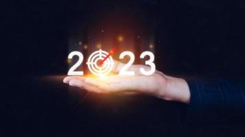 negocio objetivo y objetivo 2023 icono, mano señalando participación 2023 virtual pantalla, comienzo nuevo año 2023 con un objetivo plan, acción plan, estrategia, nuevo año negocio visión. foto