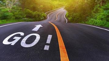 Word Go written on road in the middle of an empty asphalt road for business planning strategies and challenges or career path opportunities and change, road to success concept photo