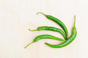 fresh green hot chilli peppers with spicy on the wooden photo