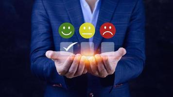 Businessman choosing happy smile face icon. feedback rating and positive customer review experience, satisfaction survey. mental health assessment. World mental health day concept photo