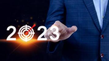 Business target and goal 2023 icon, hand pointing holding 2023 virtual screen, Start new year 2023 with a goal plan, action plan, strategy, new year business vision. photo