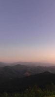vertical view of Sunset in over natural winter mountain range with some cloud fog.Flores tropical paradise. Mountain Range Silhouette Sunrise Sunset Aerial View. video