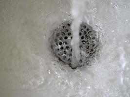 agua que fluye enjuague corriendo en el fregadero gotas rociar foto