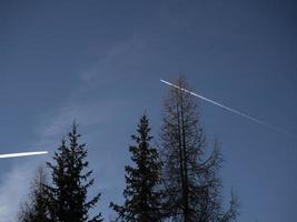 airplaine wakes on blue mountain dolomites sky photo