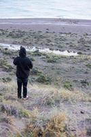 hombre mirando a amanecer en mar leones Patagonia playa foto