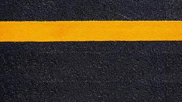 Yellow line on new asphalt detail, Street with yellow line texture photo