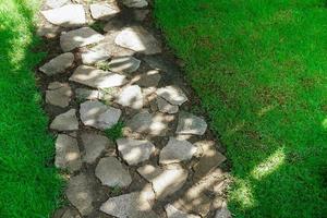 Texture of sidewalk concrete floor and grassy design,Stone walkway with green grass in the park photo