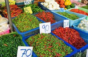 Fresco rojo y verde caliente chiles en un cesta vendido a local mercado en Tailandia foto