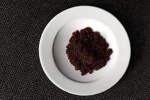 Luxury caviar food on white plate flat lay. photo