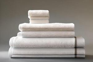 Clean various size white folded towel nice and tidy stack each other for fitness, bath, swimming, massage and spa marketing background and design material isolated on grey background. photo