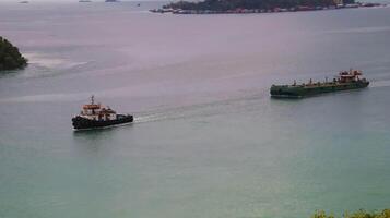 Tugboat and a barge or flat bottomed vessel moving at the sea. photo