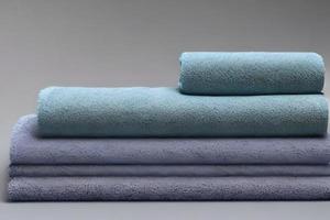 Clean soft blue and green color folded towel nice and tidy stack each other for fitness, bath, swimming, massage and spa marketing background and design material isolated on grey background. photo