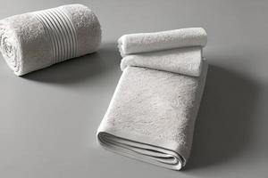 Clean white folded and roll towel nice and tidy stack each other at the table for fitness, bath, swimming, massage and spa marketing background and design material isolated on grey background. photo