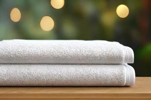 Clean two white color folded towel nice and tidy stack each other at the outdoor table for fitness, bath, swimming, massage and spa marketing background and design material. photo
