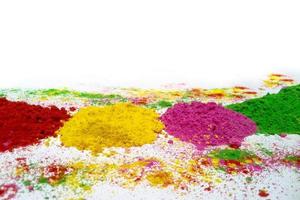 happy holi indian color festival gulal background, different colors of holi powder on white background photo