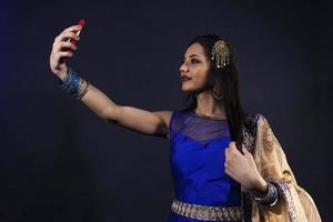 sonriente hermosa indio niña toma un selfie foto
