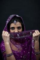 retrato de sonriente hermosa indio niña vistiendo tradicional púrpura ropa foto