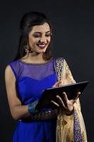 smiling beautiful indian girl consulting his laptop photo