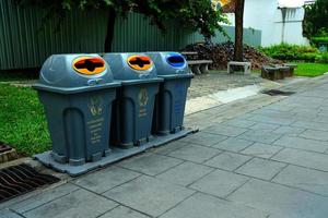 cerca arriba Tres reciclaje contenedores en el público parque. foto