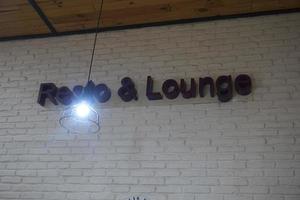 a sign resto and lounge plastered on the wall of a cafe photo