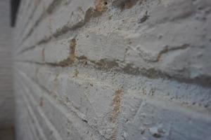 The brick wall is painted white. Old brick wall. photo