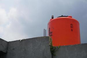 big orange water reservoir on the roof of the house. photo