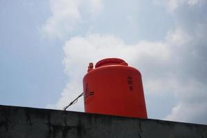 big orange water reservoir on the roof of the house. photo