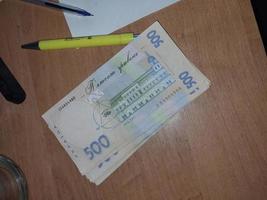KYIV, UKRAINE - DECEMBER 13, 2023 Banknotes of the Ukrainian hryvnia lie on the table photo