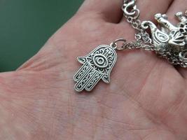 Religious metal symbol medallion in hand photo