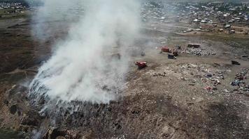 case e persone vicino il discarica. fuco volante al di sopra di un' fumo città scarico. video