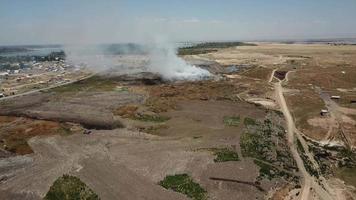 casas y personas cerca el vertedero zumbido volador terminado un de fumar ciudad vertedero. video