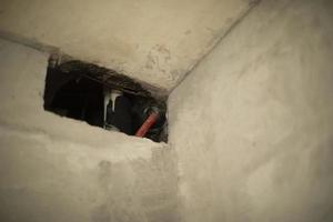 Hole in wall. Home repair. Concrete surface. Ventilation in apartment. photo