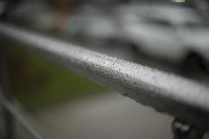 Wet handrail. Steel pipe in water droplets. Silver steel pole. photo