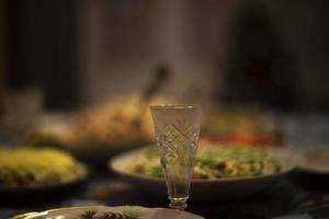 Feast in Russia. Glass of vodka on table. Festive table with food. photo