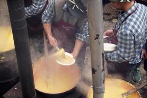 RANGO, ITALY - DECEMBER 8, 2017 - People cooking polenta traditional corn wheat meal photo