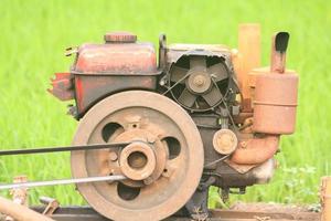 The old red water pump that is spinning at full power to pump water into the rice fields of farmers during the rice growing season in rural Thailand. photo