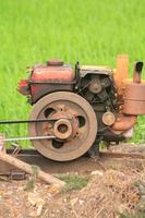 The old red water pump that is spinning at full power to pump water into the rice fields of farmers during the rice growing season in rural Thailand. photo