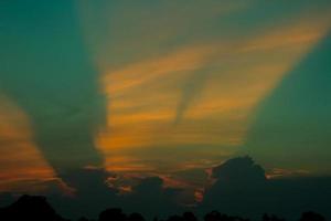 atmósfera en el noche cielo como el Dom conjuntos - vigas - de el Dom y nubes crear hermosa colores y muchos colores, creando un calentar y romántico atmósfera en un verano noche. foto