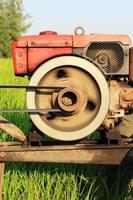 The old red water pump that is spinning at full power to pump water into the rice fields of farmers during the rice growing season in rural Thailand. photo