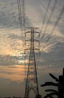High-voltage poles are used to carry electricity for industrial plants and people to use in the farmer's fields in the evening. Beautiful sky atmosphere and designed by electrical engineers. photo