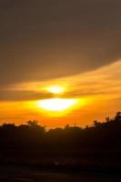 The big sun is about to set in the evening as the sky is a warm and frightening yellow-orange, something nature has created in rural Thailand. photo