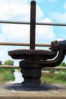 Hand-cranked water-gate for closing and opening water in irrigation canals for agriculture. Farmers' cultivation requires water for cultivation. photo