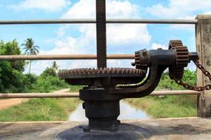 Hand-cranked water-gate for closing and opening water in irrigation canals for agriculture. Farmers' cultivation requires water for cultivation. photo