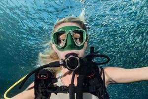 beauty blonde diver girl looking at you while swimming underwater photo