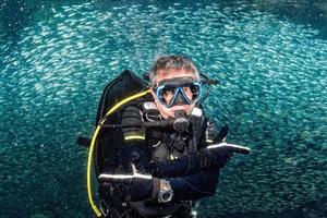 beautiful diver in fish and corals reef background photo